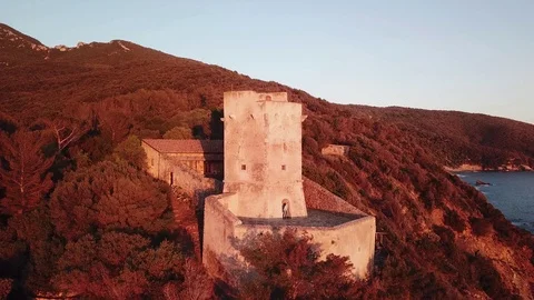 Aerial view of an ancient tower on the cliff at Sunset Stock Footage 106541240