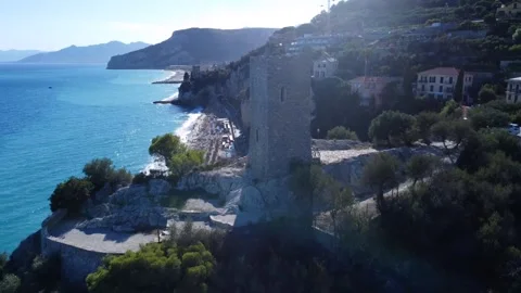Aerial view of an ancient tower overlooking the sea of Finale Ligure Stock Footage 253127108