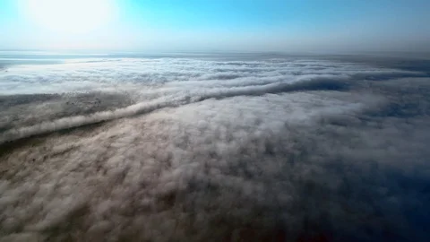 Aerial view approaching from dense fluffy clouds to city overhead view at Stock Footage 115643111