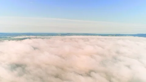 Aerial view approaching from dense fluffy clouds to city overhead view at sunset Stock Footage 115799775