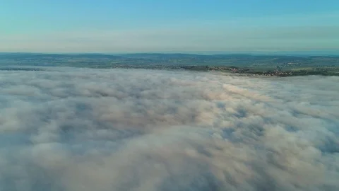 Aerial view approaching from dense fluffy clouds to city overhead view at sunset Stock Footage 115802963