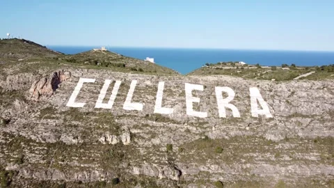 Aerial view approaching the large sign of Cullera painted Stock Footage 268574535