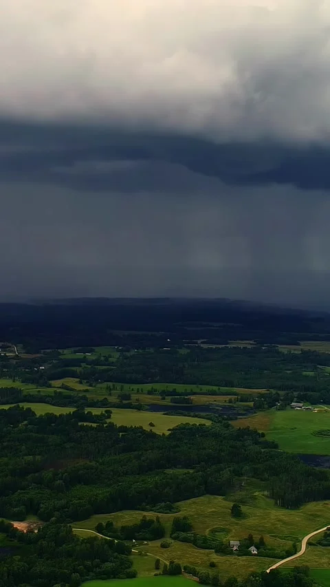 Aerial view of approaching storm clouds over lush green countryside, vertical 動画素材 305170459