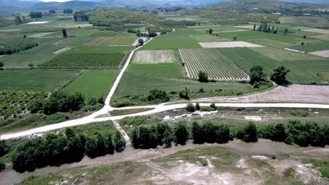 Aerial view of arable land with a small river in the middle in  Aridea Greece Stock Footage 115035550
