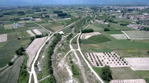 Aerial view of arable land with small river and village in Aridaia Greece Stock Footage 115049836
