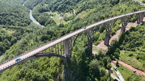 Aerial View of an Arch Bridge Across a Forested River Canyon Stock Footage 345576407