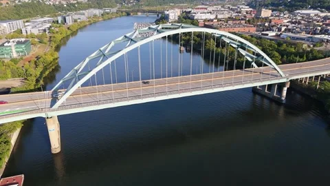 Aerial view of an arch bridge with traffic over a river near a city 库存影片 325219243