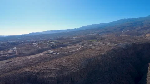 Aerial View of Arid Volcanic Terrain and Farmland in Tenerife Stock Footage 344851391