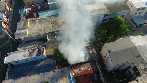 Aerial view around a building on fire, caused by a bomb, dark smoke Stock Footage 142404801