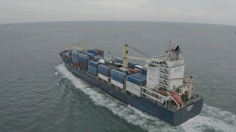 Aerial view around a floating cargo ship in route Stock Footage 120467527
