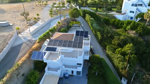Aerial view around modern white villa with solar panels and water heater, Greece Stock Footage 337115479