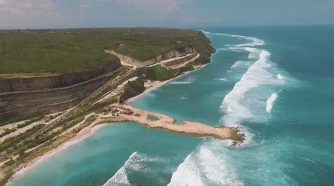 Aerial view of artificial mound in ocean and serpentine road behind it Stock Footage 67847524