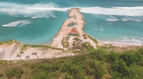 Aerial view of artificial mound in ocean behind a cliff Stock Footage 67847585