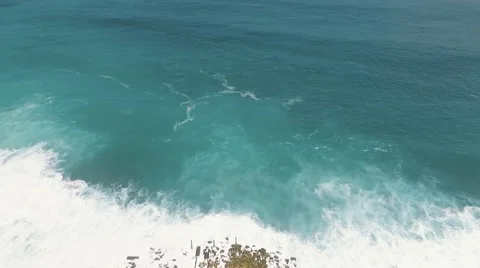 Aerial view of artificial mound in ocean and cliff behind it Stock Footage 67847605