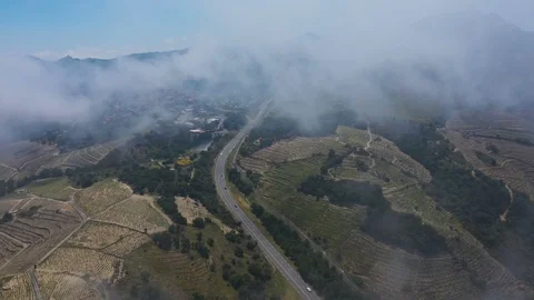 Aerial view ascending through clouds from busy road below Stock Footage 119571240