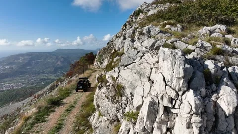 Aerial View of ATV Buggy Driving Up Mountain Off-road Path - Sunny Day 動画素材 299708986