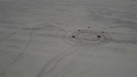 Aerial view of ATV driving down a beautiful wide open beach with crashing ocean Stock Footage 77707638