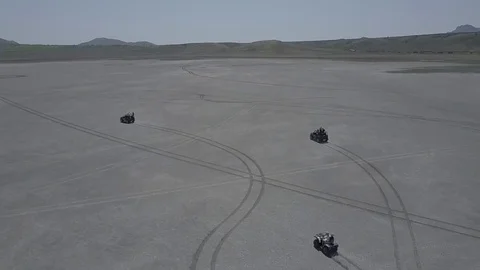 Aerial view of ATV driving down a beautiful wide open beach with crashing ocean Stock Footage 77707665