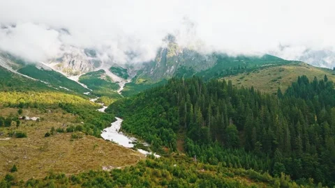 Aerial view of Austrian Alps with forest, river and mountain peaks in clouds Stock Footage 320322304