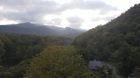 Aerial view of autumn mountain forest and a house in the valley Stock Footage 337888632