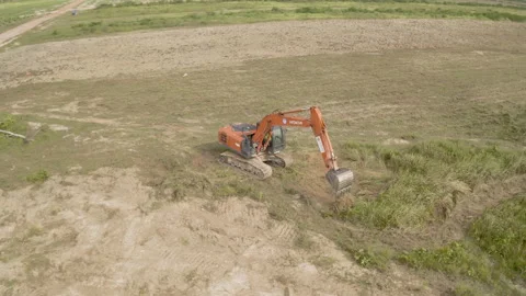 Aerial view of backhoe is digging grove in the agricultural garden Stock Footage 156991008