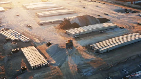 Aerial view of a backhoe loader is working on a building plot with many concrete Vídeos de archivo 165310896
