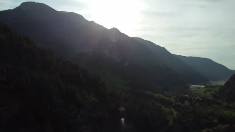 Aerial View of Backlit Mountain Gorge with Sun Flare and Deep Shadows Stock Footage 332216734