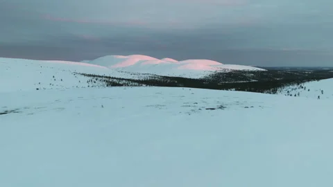 Aerial view backwards over a skier standing on a snowy fell, winter sunset Stock Footage 278381044