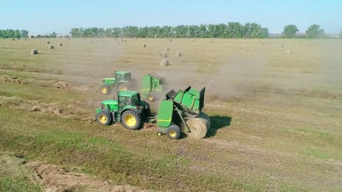 Aerial view of a baler working in the field. Machine that makes round hay stacks Video stock 242343889
