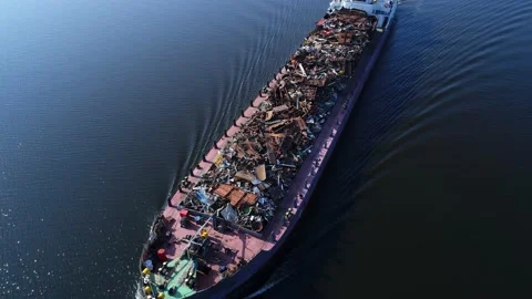 Aerial view. A barge loaded with scrap metal and waste floating on a wide river. Stock Footage 236190013