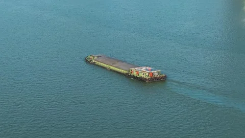 Aerial view of barge navigates river in urban setting with modern skyscrapers Stock Footage 310117364