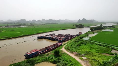 Aerial view of barges on a river flowing through rice paddies and karst mou.. 스톡 동영상 335081526