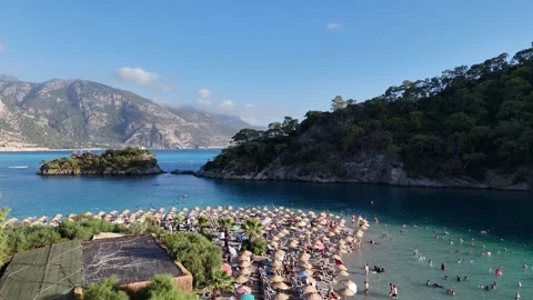 Aerial view of a beach with beach umbrellas swimming people Stock Footage 336385603