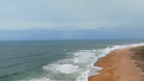Aerial view of beach with big waves in Nazare, Portugal. Two people fishing.. Stock Footage 239577676