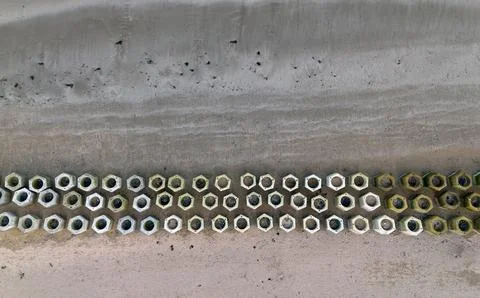 An aerial view on the beach with a hexagonal shaped of cement blocks on the sand Stock Photos
