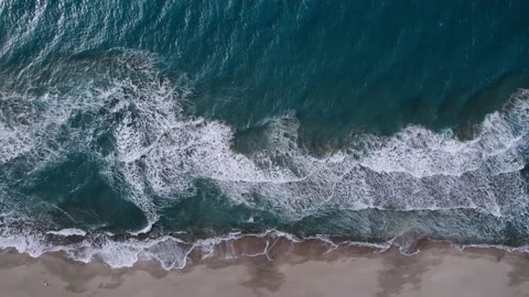 Aerial view of a beach. Slow motion video of waves crashing on the sand beach. Stock Footage 169044353