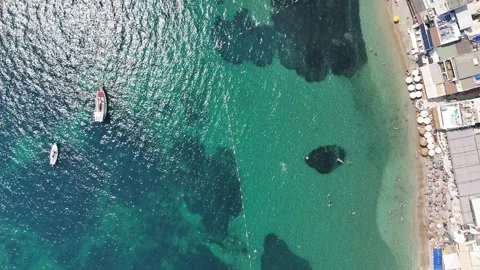 Aerial view of a beach by summer town coast with turquoise sea Stock Footage 336568274