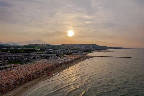 Aerial view of a beach at sunset with an array of colorful umbrellas on the shor Foto stock