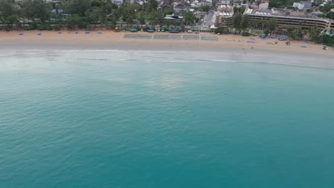 Aerial view of beach at sunset with mountains and city in background Stock-Footage 342332034