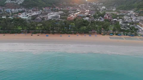 Aerial view of beach sunset with umbrellas and coastal city in background Stock-Footage 342331992