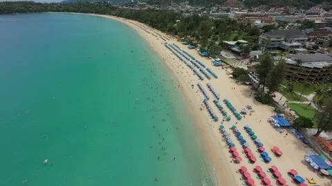 Aerial view of beach with umbrellas, clear water, and coastal buildings Vídeos de archivo 342333236