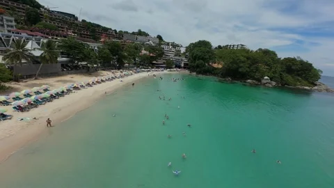 Aerial view of beach with umbrellas, clear water, and coastal buildings Vídeo Stock 342333256