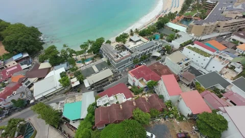 Aerial view of beach with umbrellas, clear water, and lush greenery nearby Stock-Footage 342333440