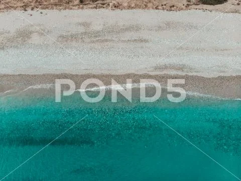 Aerial view of beach with waves and a calm feel looking down at the shoreline Stock Photos