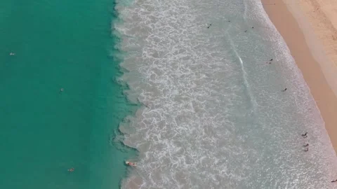 Aerial view of beach waves crashing on shore with people enjoying the water Vídeo Stock 337419141