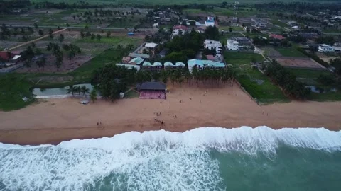 Aerial view of a beach with waves, sand, and buildings in the background Stock Footage 317658007