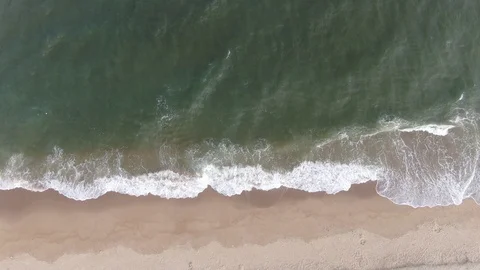 An aerial view of beach waves splashing , 4K Stock Footage 100905900