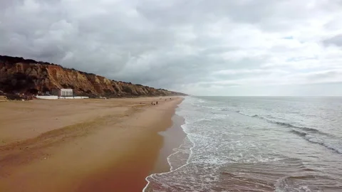 Aerial view of a beach in winter with a rum flying over the shore and the bea Stock-Footage 147680782