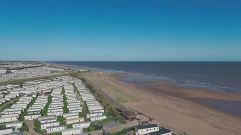 Aerial view of beachside caravans under clear skies Stock Footage 346259777