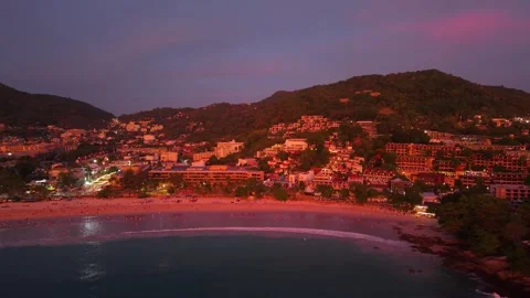 Aerial view of beachside resort at dusk with illuminated buildings and coastline 스톡 동영상 342313086